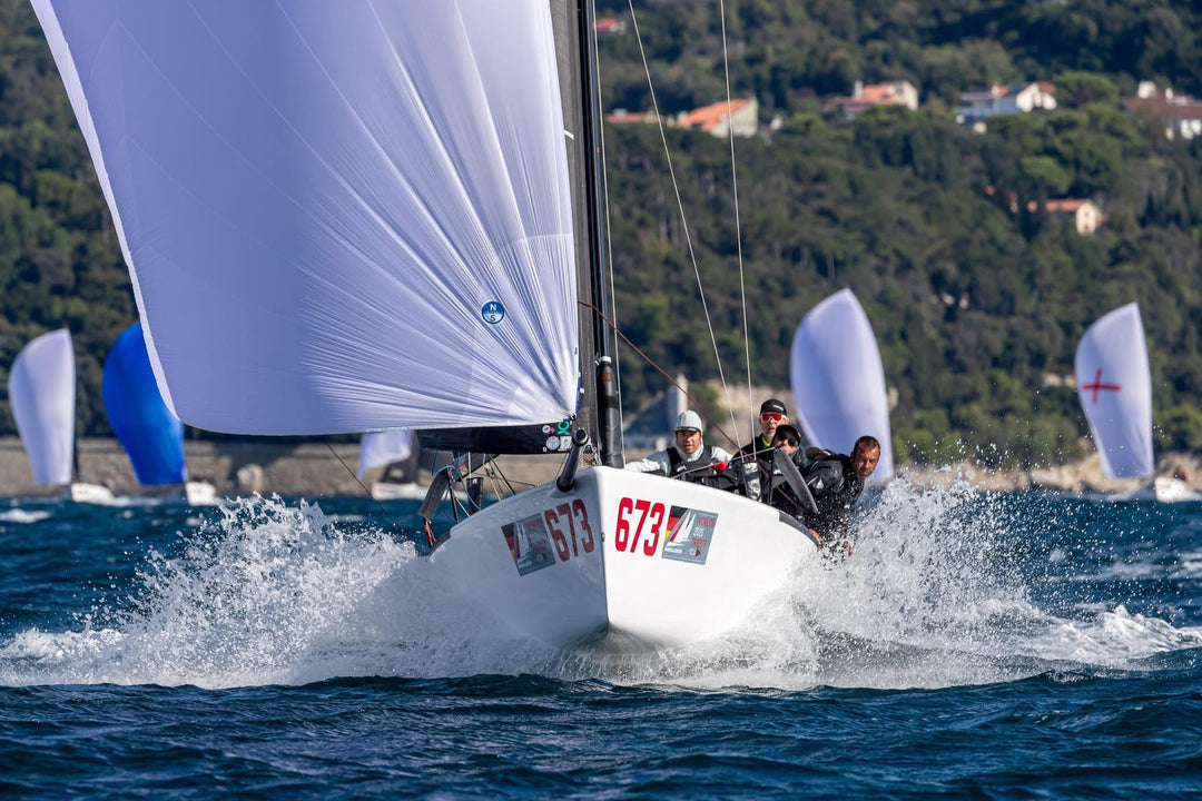 melges 24 planing downwind in front of mountains